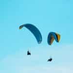 two person parachuting during clear blue sky