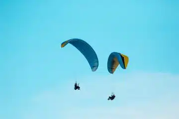 two person parachuting during clear blue sky