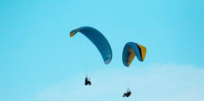 two person parachuting during clear blue sky